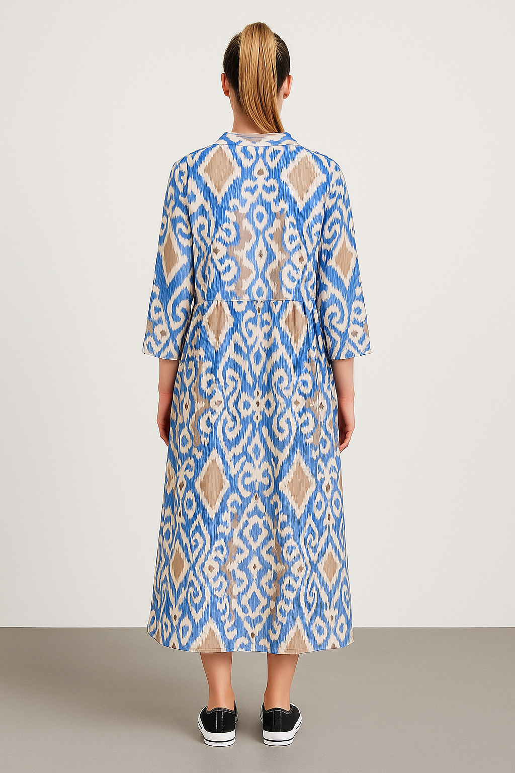 Back view of Italian Collar Button Maxi Dress in blue and beige geometric pattern on model with ponytail and black slip-on shoes