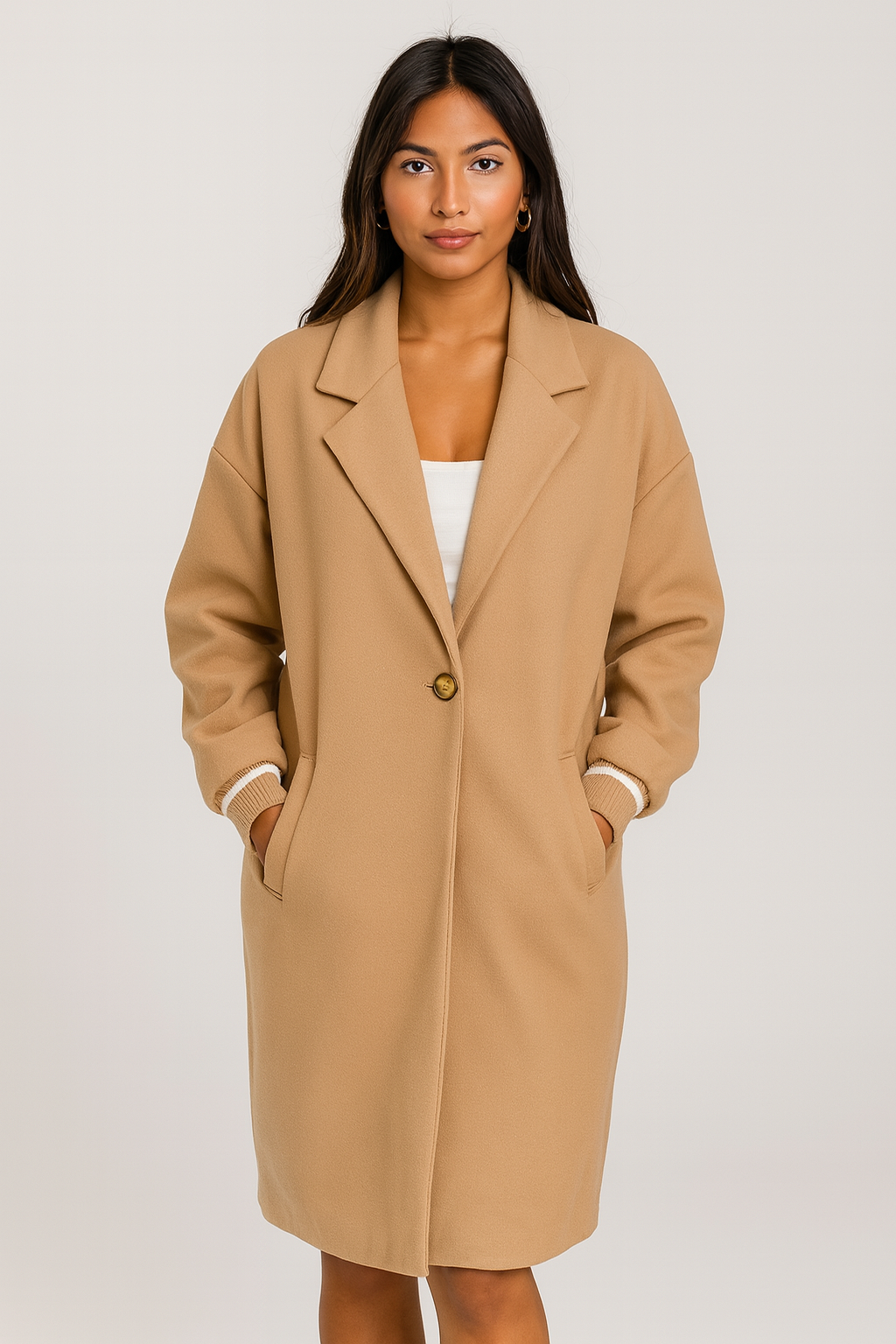 Woman wearing beige ribbed cuff sleeves coat with relaxed fit and lapel collar.