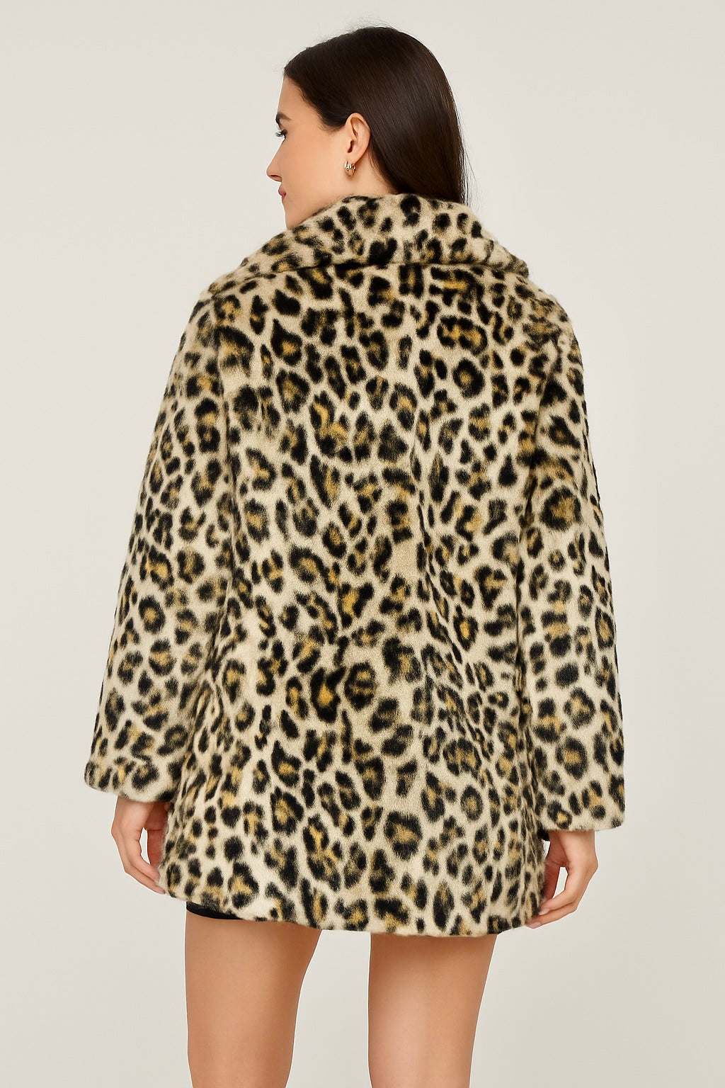 back view of a woman wearing a faux fur leopard print jacket made from soft acrylic with a bold leopard pattern and side pockets