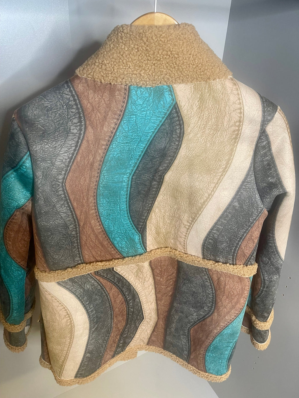 Retro multi coloured women’s jacket with vintage patchwork design and teddy bear lining on hanger