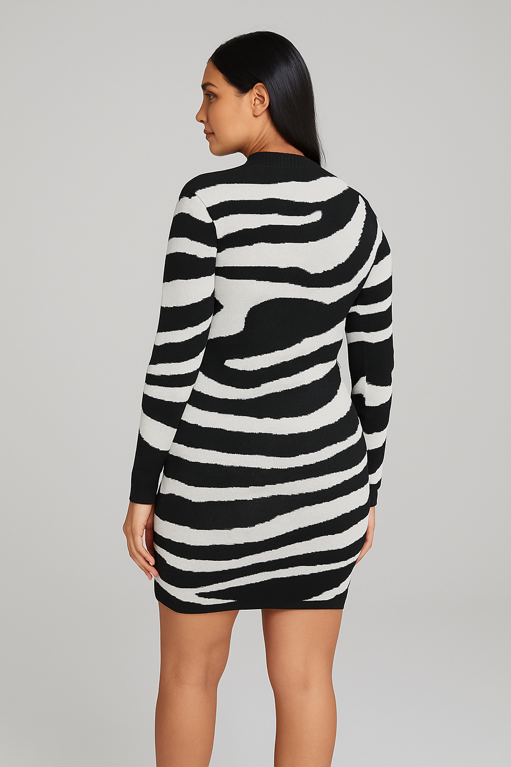 Woman wearing a black and white zebra print bodycon knitted dress with long sleeves and a round neckline, shown from the back