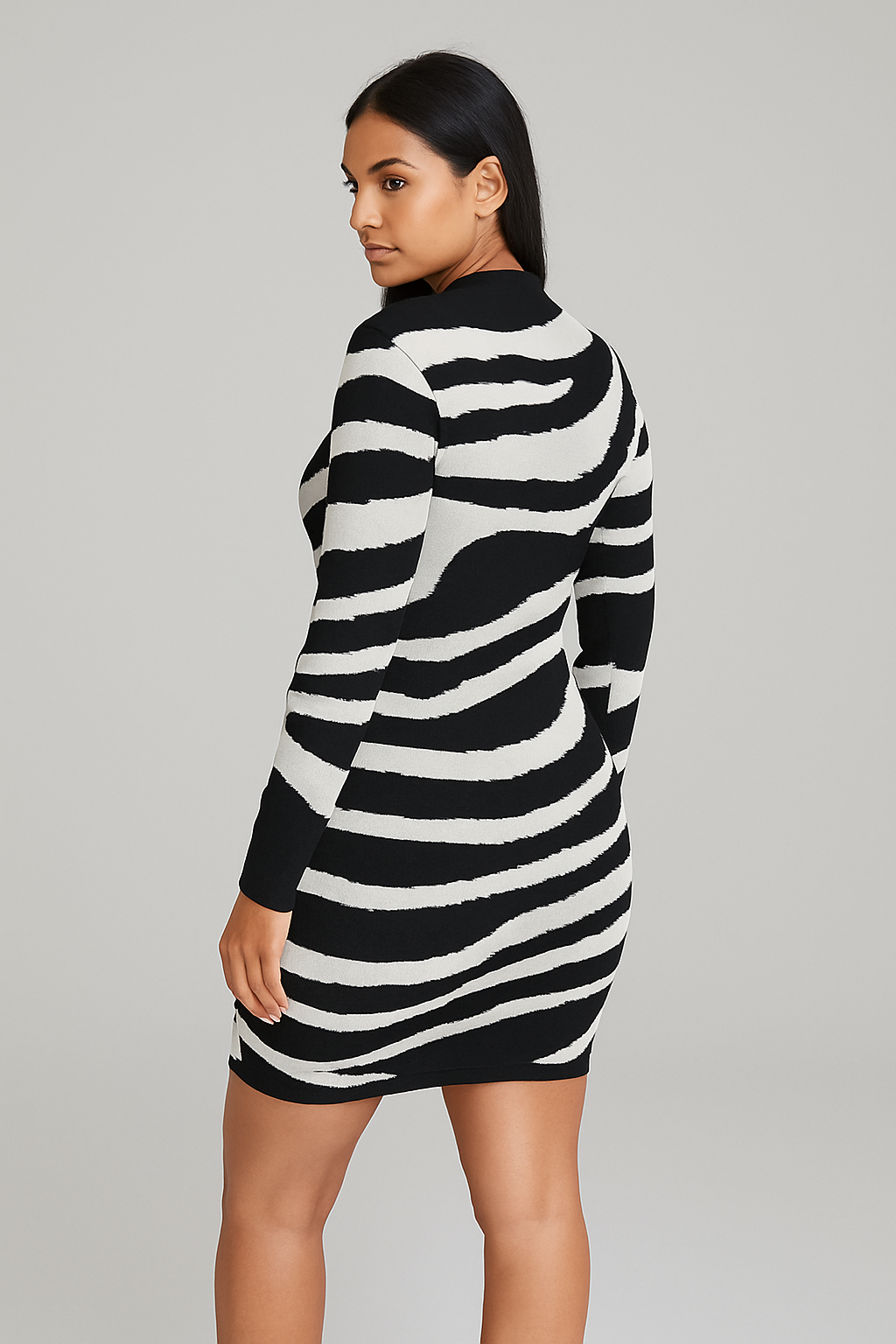 Woman wearing a black and white zebra print bodycon knitted dress with long sleeves and a round neckline, fitted silhouette.