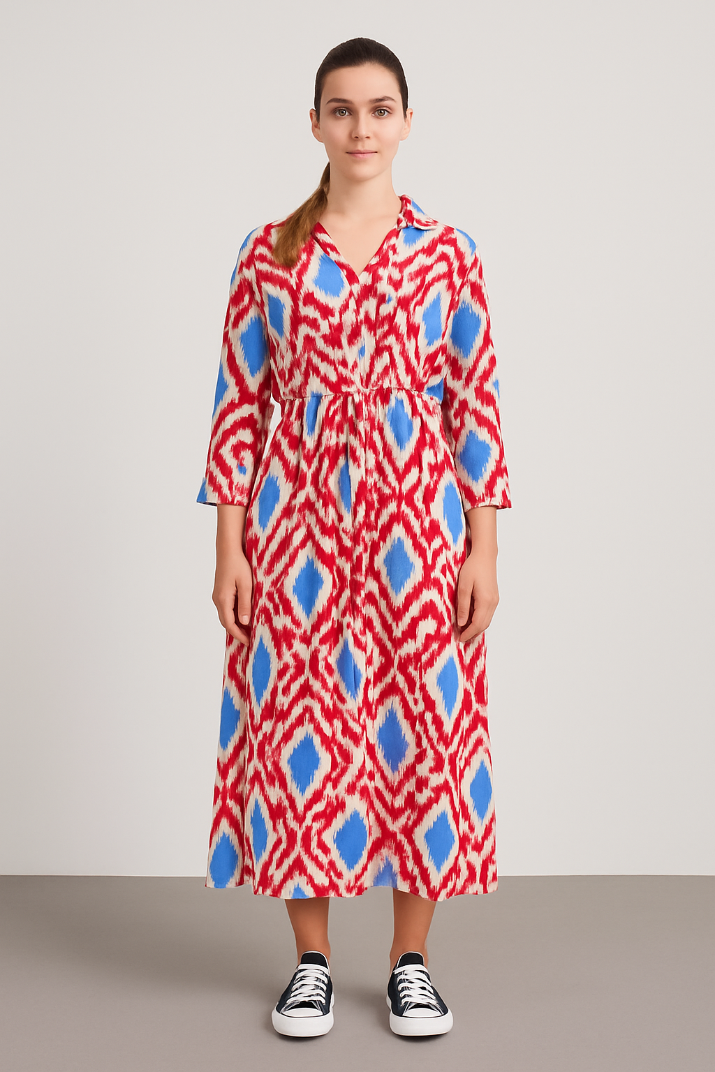 Woman wearing a red and blue patterned Italian Collar Button Maxi Dress with long sleeves and a collar, styled casually with black sneakers.