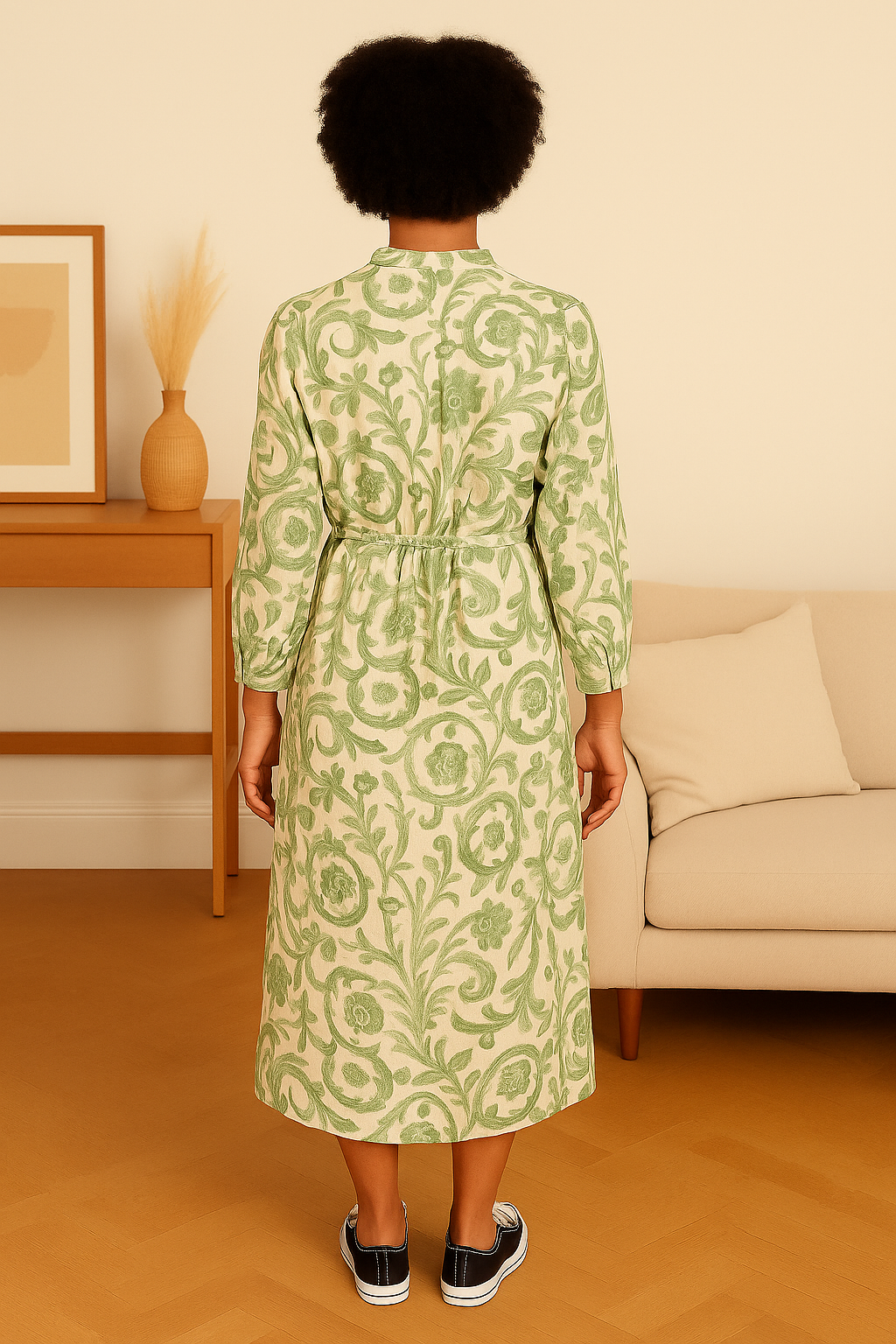 Back view of a woman wearing an Italian Maxi Dress with green floral patterns, standing in a stylish living room.