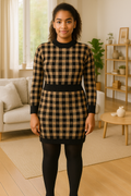 Woman wearing a black and beige checkered two piece jumper and skirt coord set in a cozy living room setting
